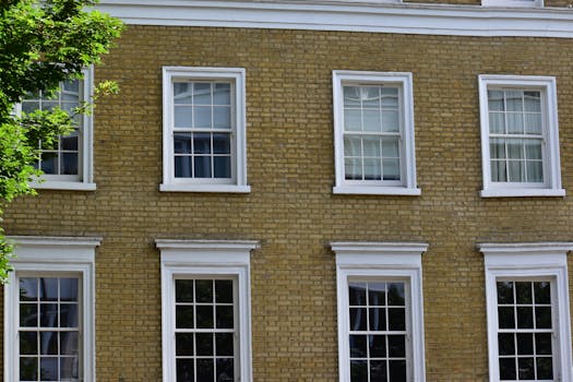 Detailed view of a vintage brick building facade with white framed windows in London.