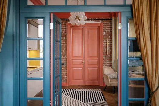 A stylish interior featuring bright blue and red doors with brick walls and modern decorations.